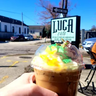 a hand holding a cup of iced coffee