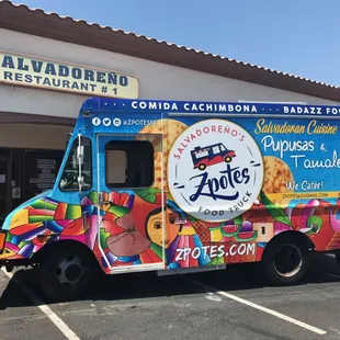 a colorful food truck parked in front of a restaurant