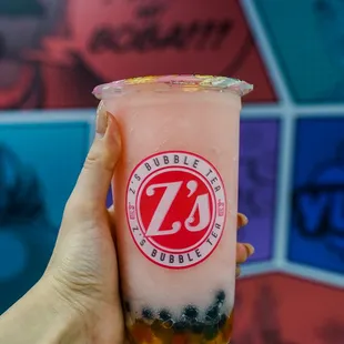 a hand holding a cup of bubble tea