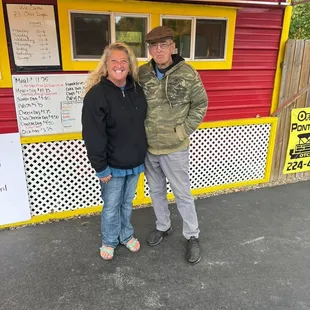 a man and a woman standing in front of a food truck
