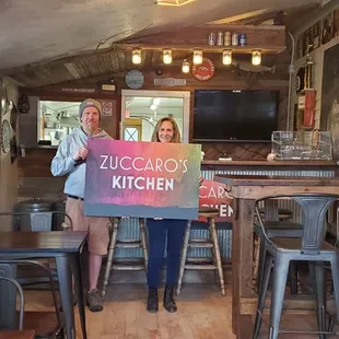 two women holding a sign