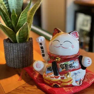  a cat figurine and a potted plant