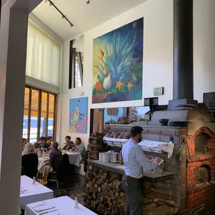 a man standing in front of a brick oven