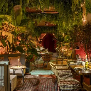 the interior of a restaurant with plants hanging from the ceiling