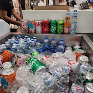 a man standing in front of a cooler filled with sodas and soft drinks