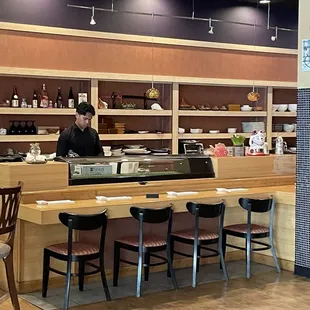 a man behind a sushi counter