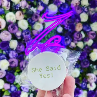 a person holding a sticker that says she said yes