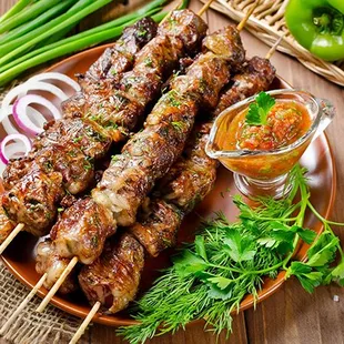 a plate of skewers of meat and vegetables