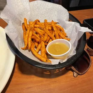 a basket of french fries and a bowl of sauce