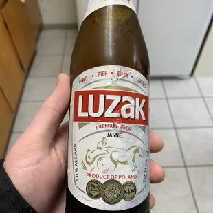 a person holding a bottle of luzak