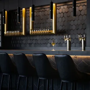 a row of bar stools with a glass of wine