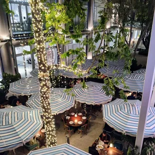 an outdoor dining area with blue and white striped umbrellas